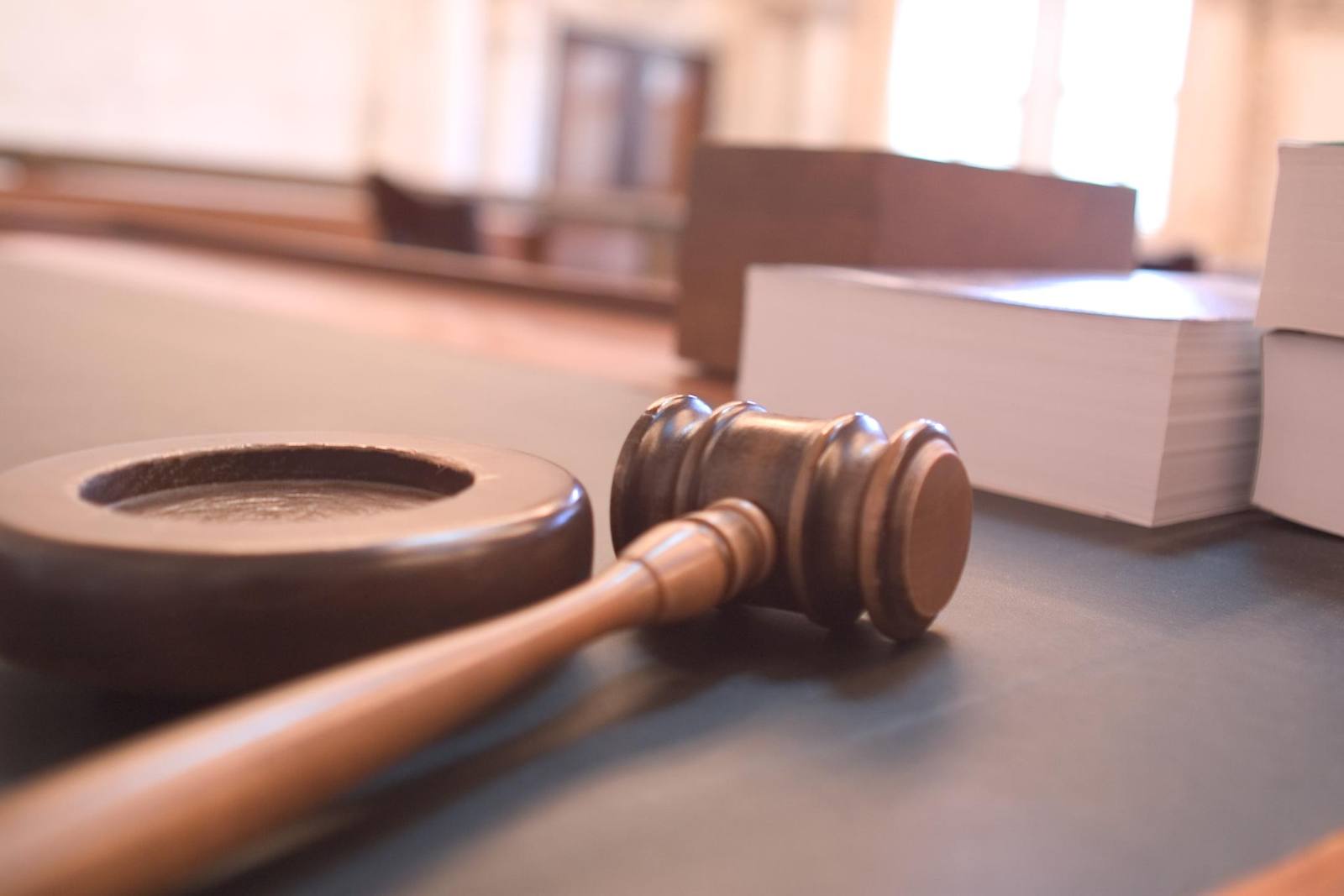 A judge's gavel resting on a sound block in a courtroom