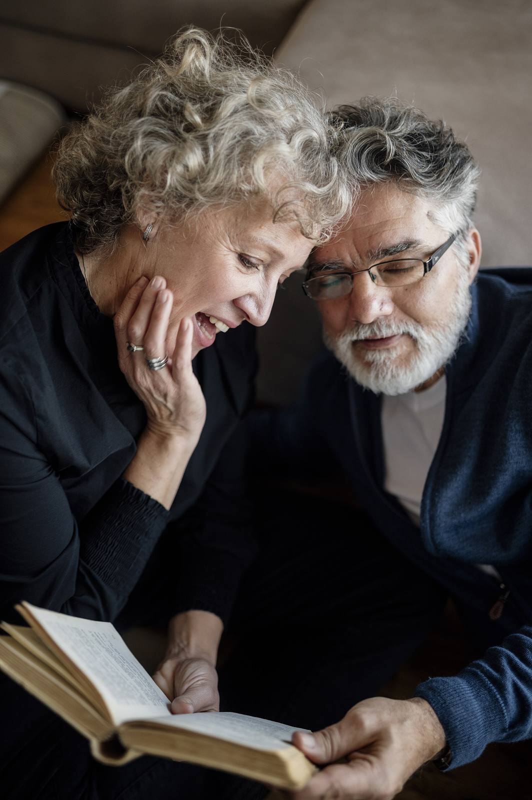 An elderly couple reading together at home