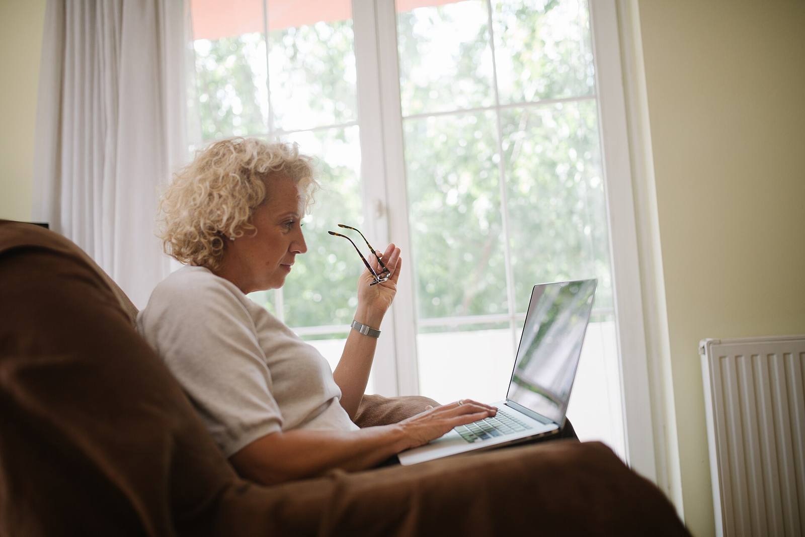 An older woman at home using a laptop