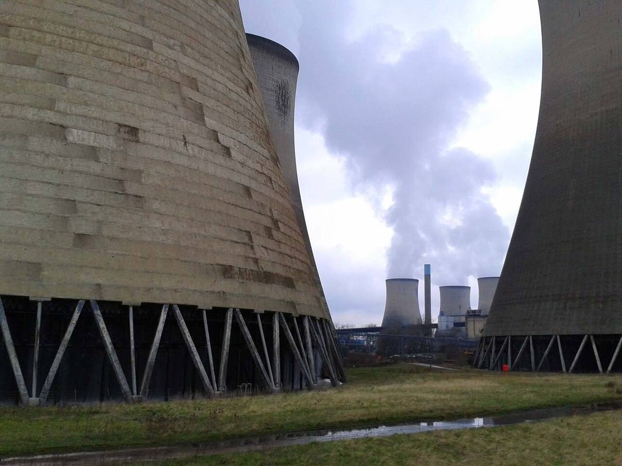 The concrete cooling towers of Didcot Power Station, seen close up with further towers and vapour in the distance