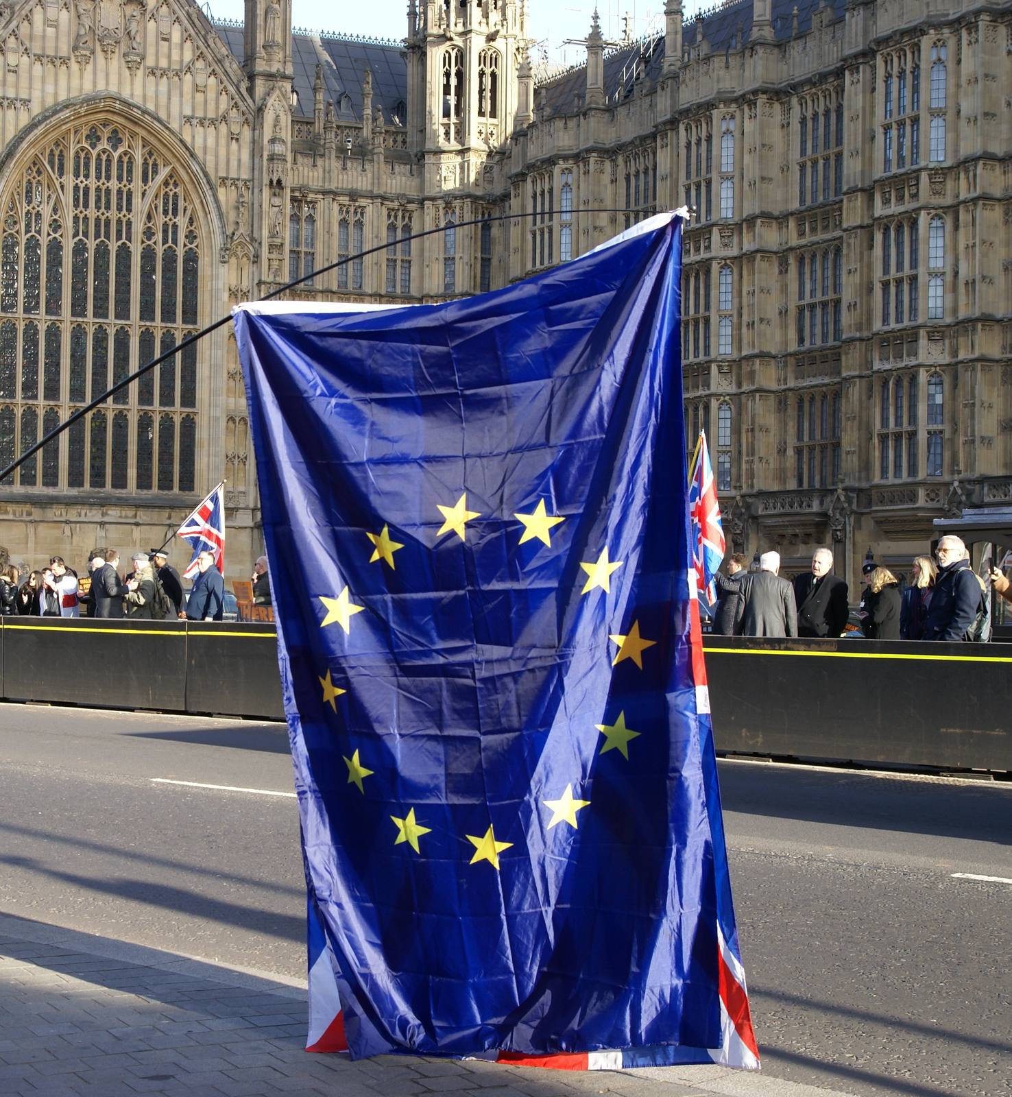 A European Union flag held up in front of the Palace of Westminster