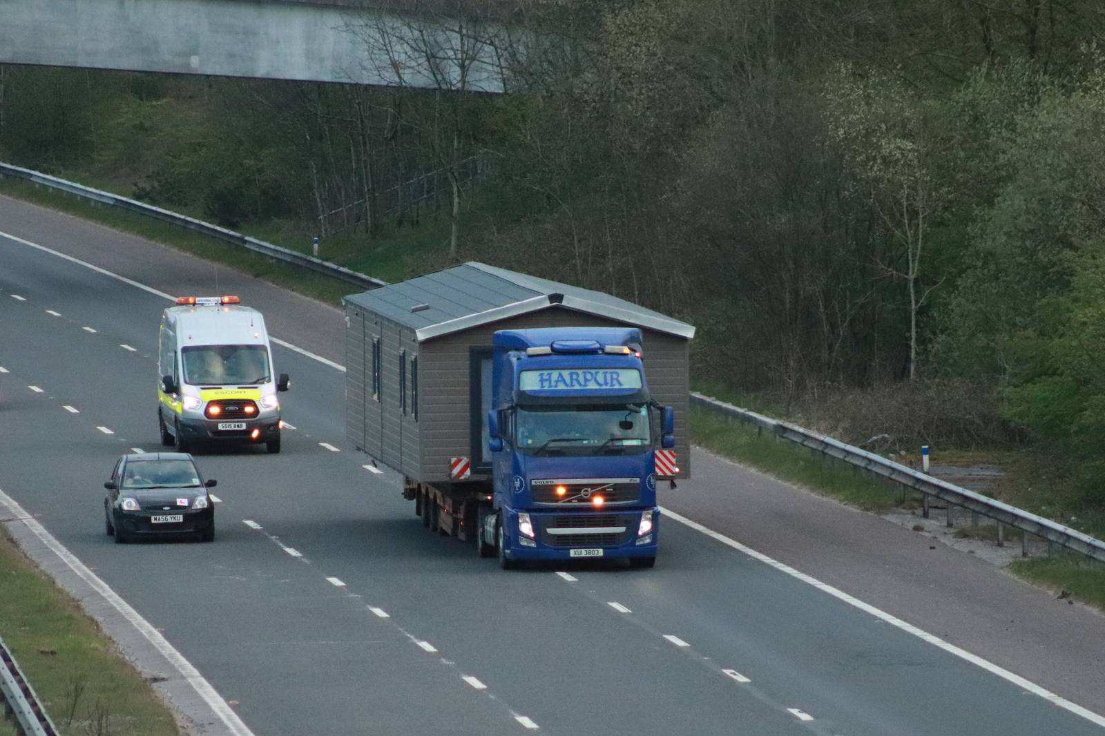 A heavy goods vehicle hauling a load on a British motorway