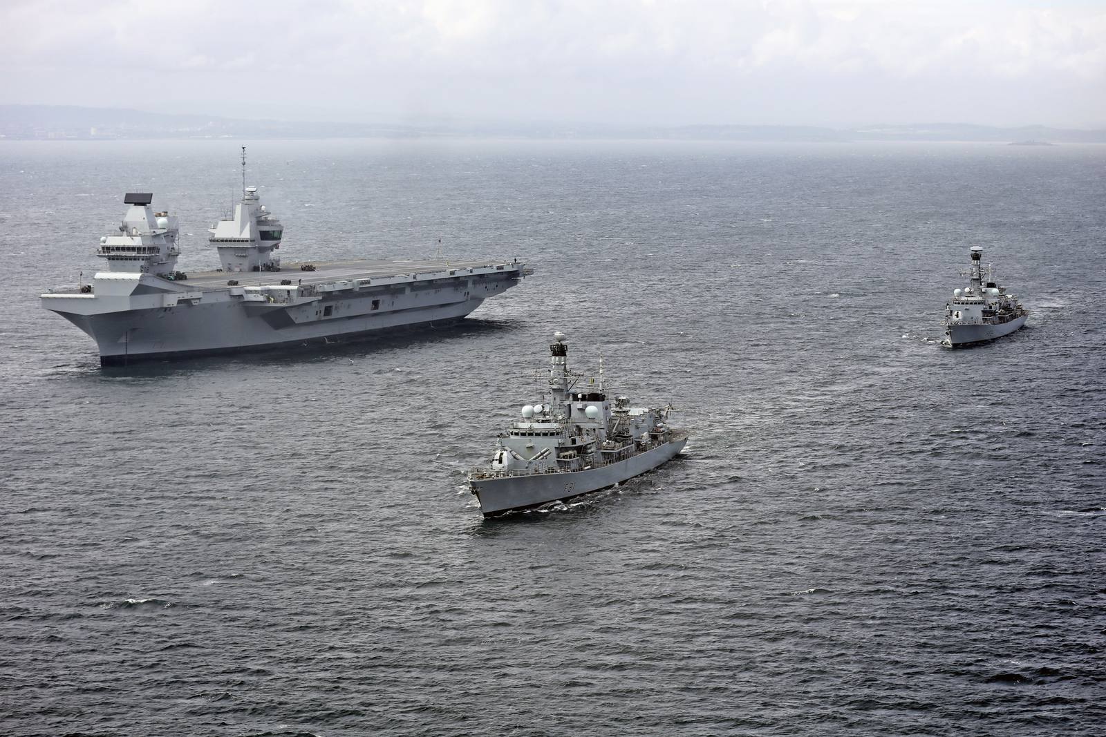 HMS Queen Elizabeth, a Royal Navy aircraft carrier, underway at sea with escort vessels