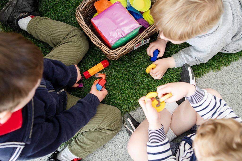 Young children playing with toys in a nursery classroom