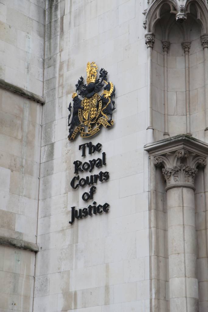 The royal coat of arms and Royal Courts of Justice lettering on the building's stone facade