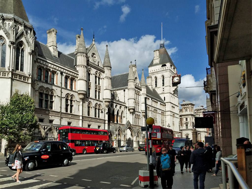 The Royal Courts of Justice on the Strand in London, with buses and taxis passing