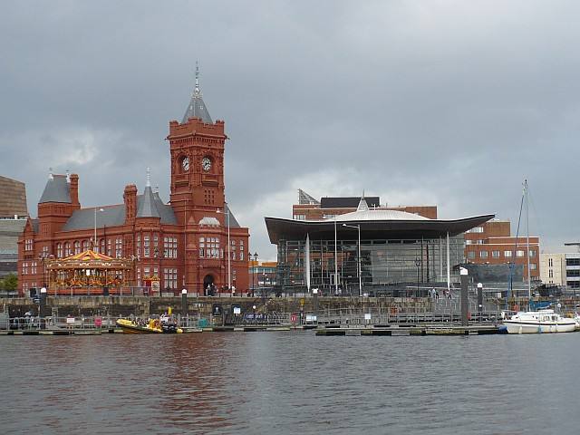The red brick Pierhead Building and the Senedd seen across the water in Cardiff Bay