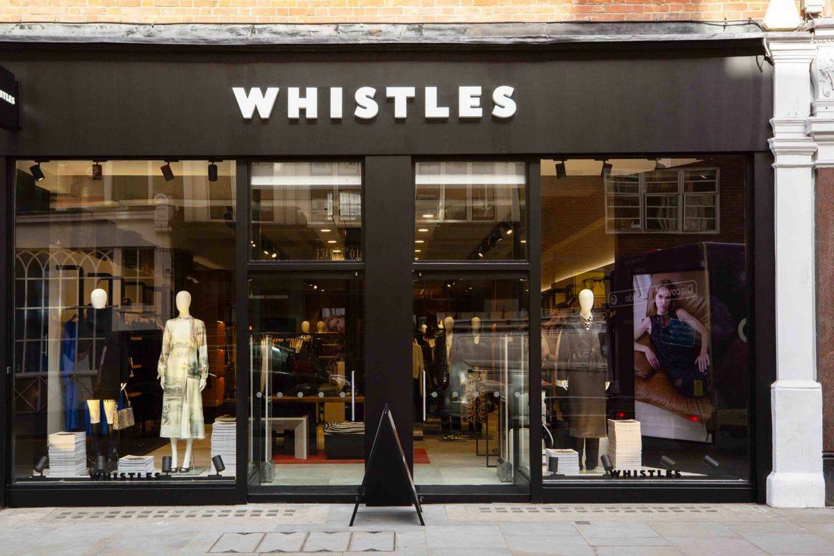 The front of a Whistles store, with mannequins and clothing visible in the windows